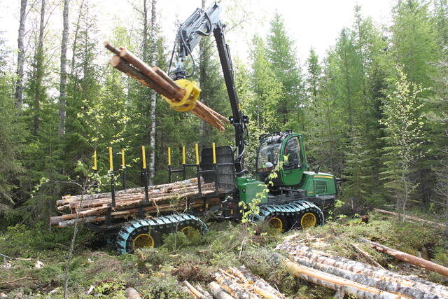 John Deere 810E -ajokone kuormaamassa puutavaraa